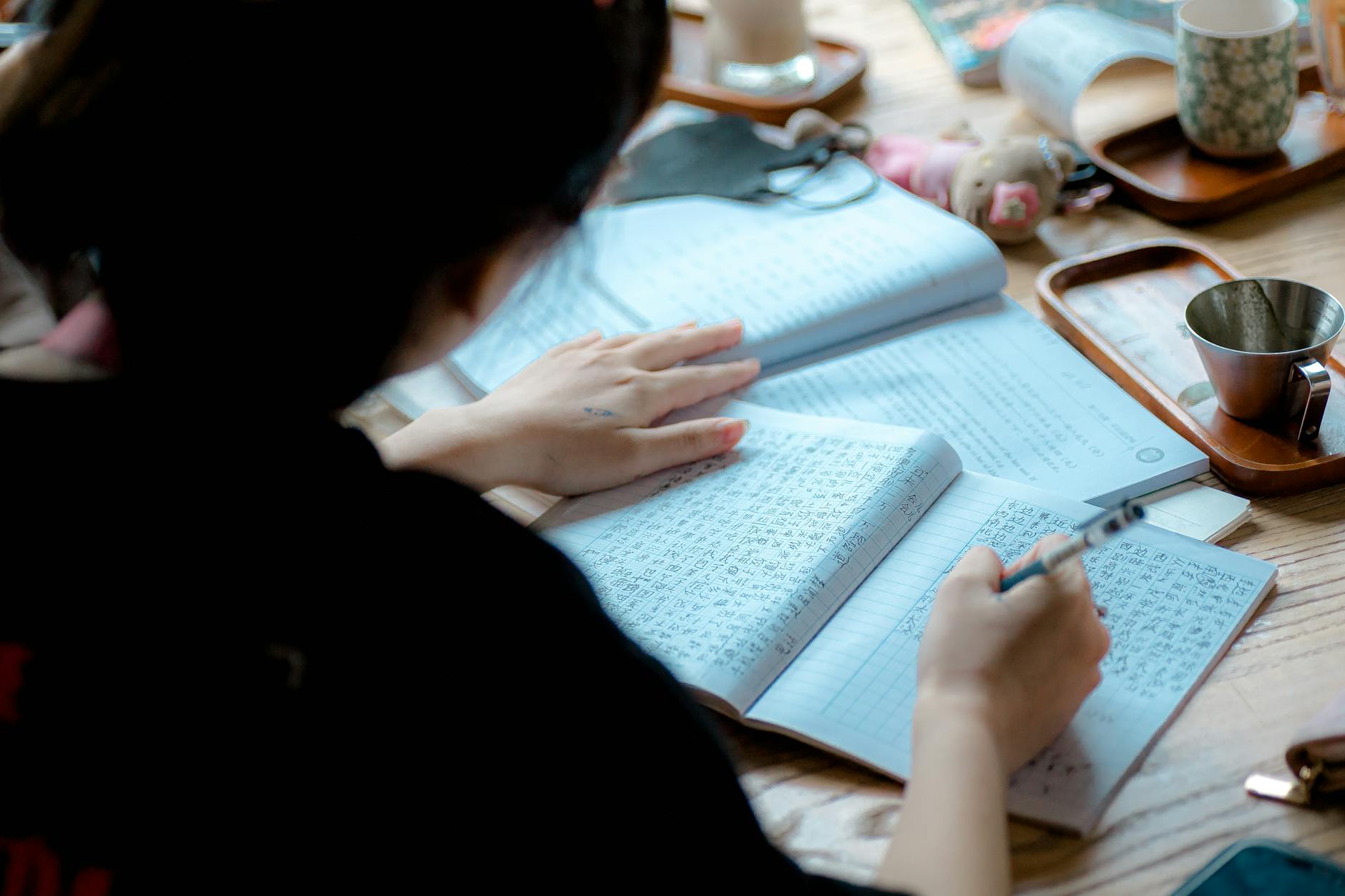 Osoba robi notatki podczas nauki języków obcych przy biurku