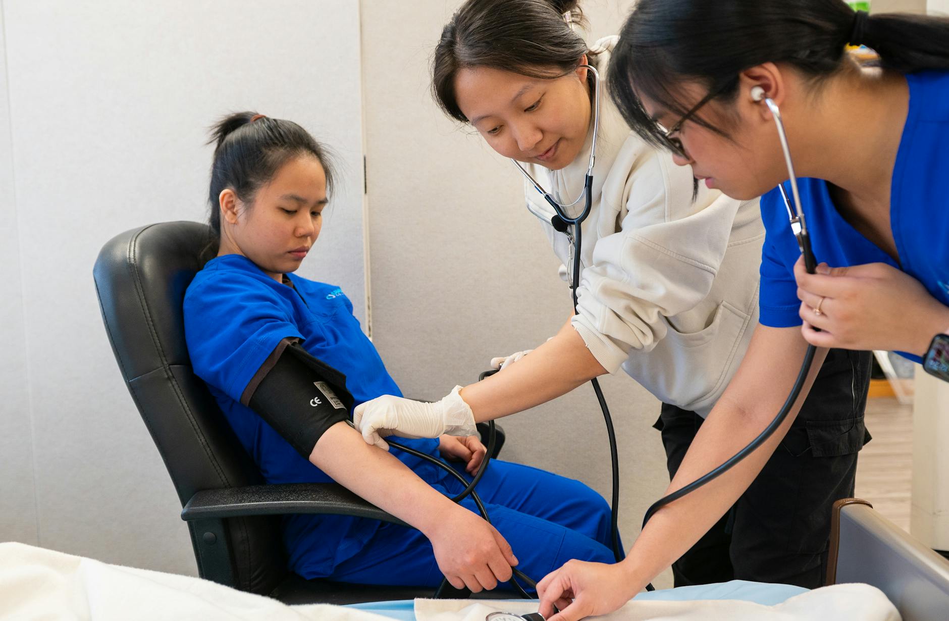Pielęgniarka mierzy ciśnienie studentowi w gabinecie medycznym Pielęgniarka mierzy ciśnienie studentowi w gabinecie medycznym