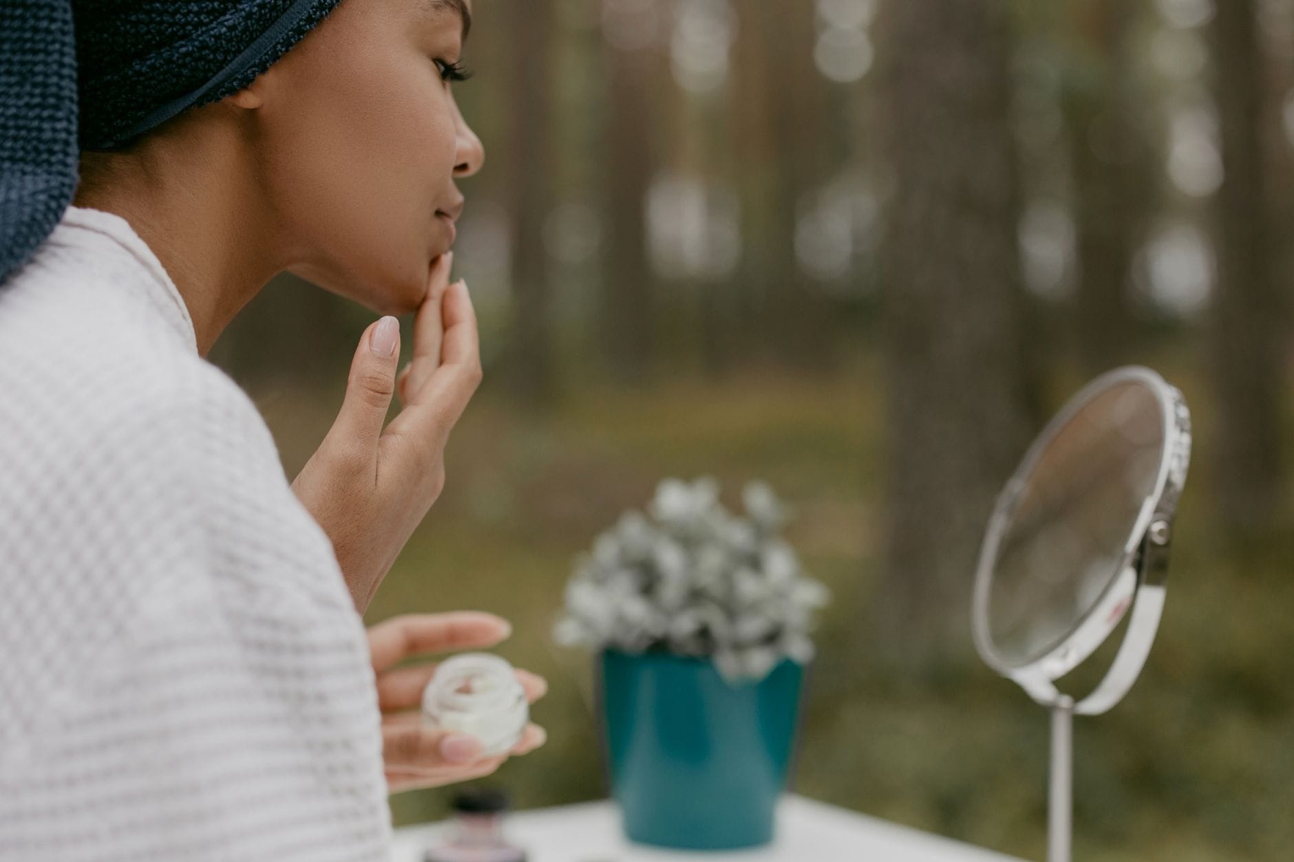 Kobieta wykonuje naturalną pielęgnację twarzy w lesie