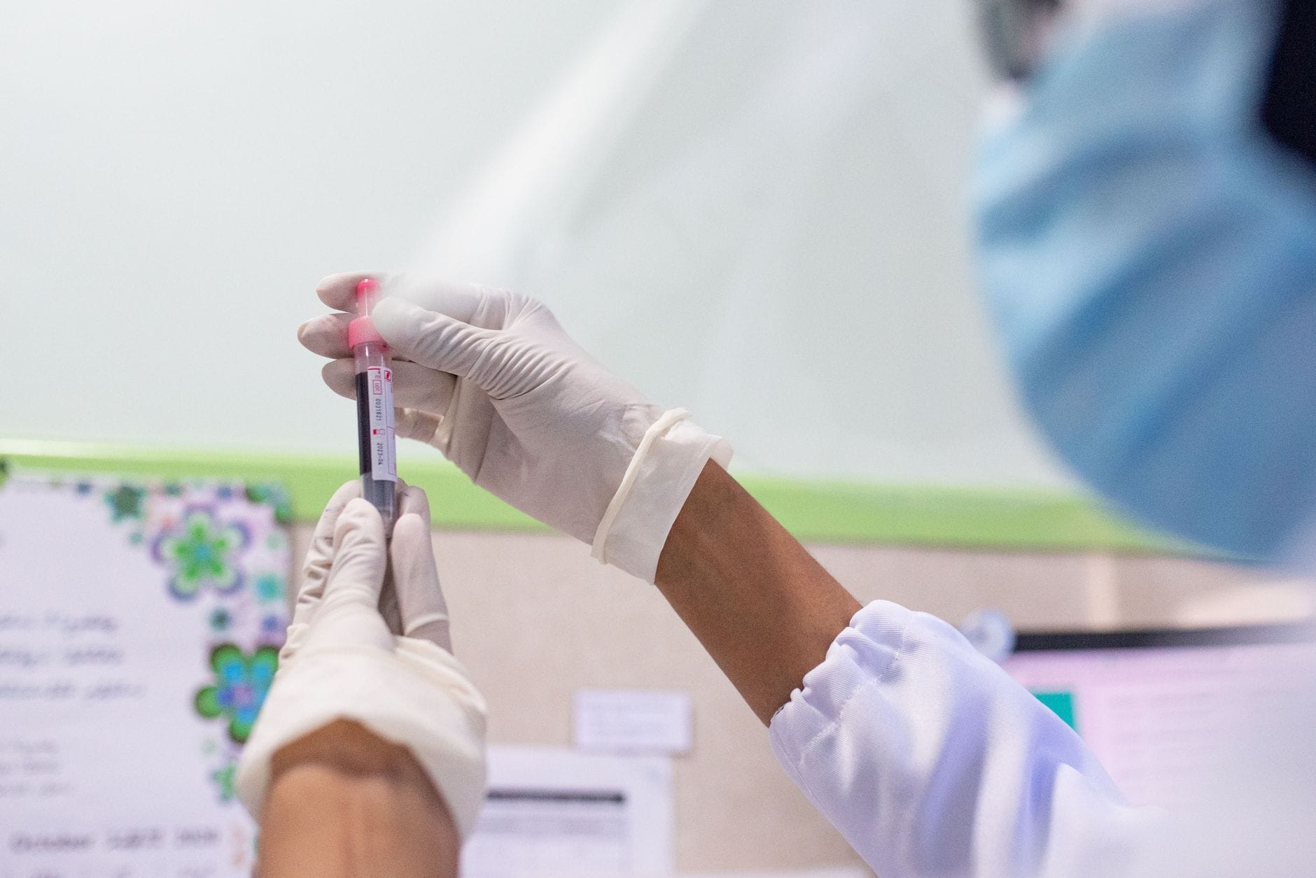 Pracownik laboratorjum analizuje próbkę krwi pod kątem markerów HIV
